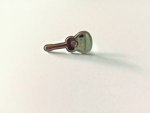 Der kleine silberne Barden-Pin in Form einer Gitarre
