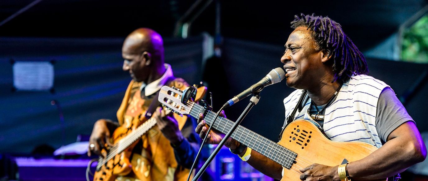 Habib Koité aus Mali und ein weiterer Musiker spielen ihre Instrumenten auf der Bühne