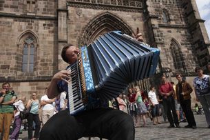 Ein Straßenmusiker mit Akkordeon vor der Lorenzkirche